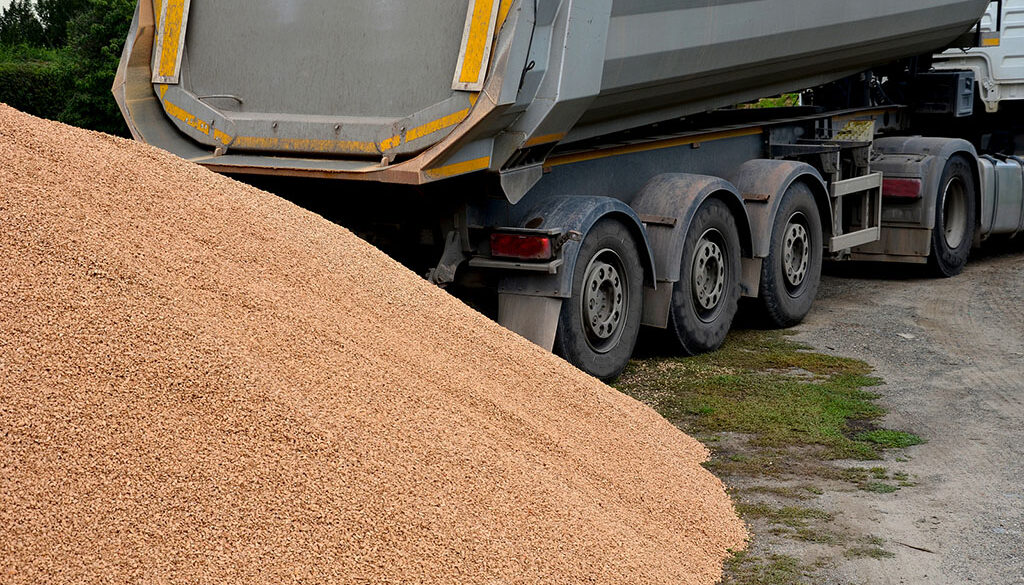 A Moving Floor Trailer In Front Of A Large Pile Of Gravel Belt Vs Walking Floor Trailer